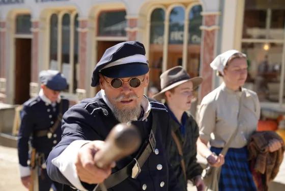 Costumed goldfields police reenactors patrolling with props during a heritage performance, from Australia’s most visited outdoor museum and heritage attraction.