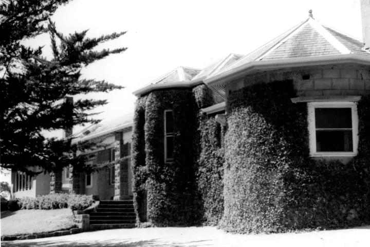 Historic black-and-white photograph of Eurambeen homestead, featuring ivy-covered stone walls, bay windows and a landscaped garden.