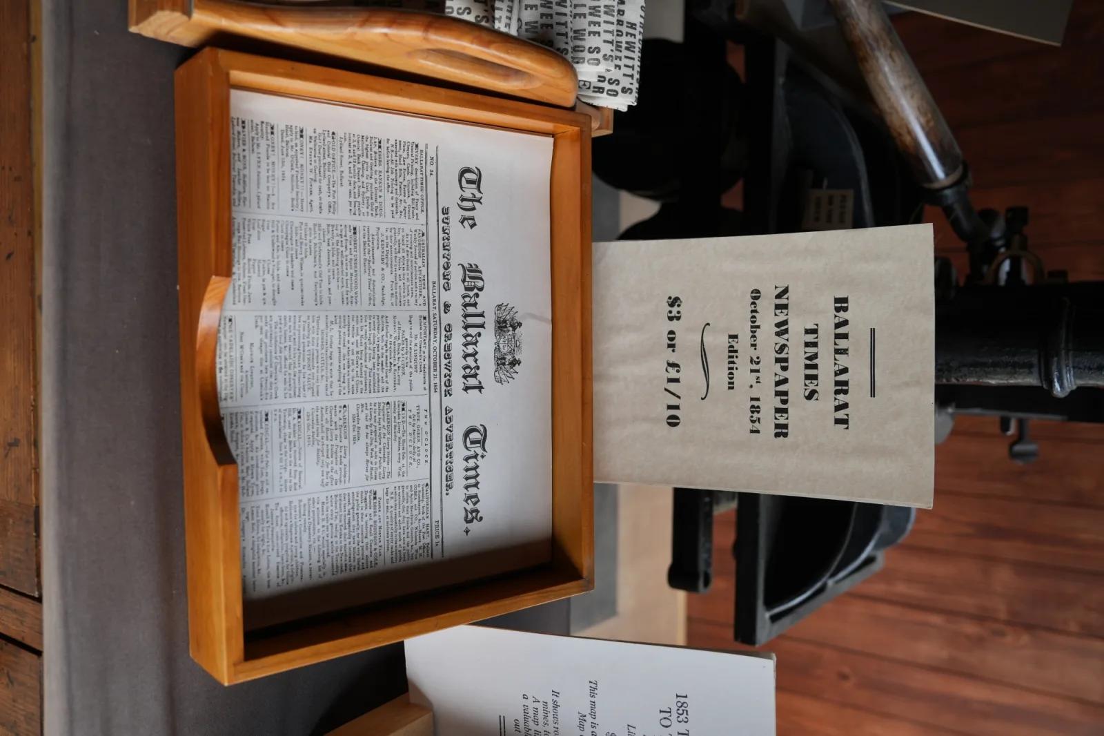 Replica 1854 Ballarat Times newspaper displayed beside a framed historical edition and printing equipment at Sovereign Hill.